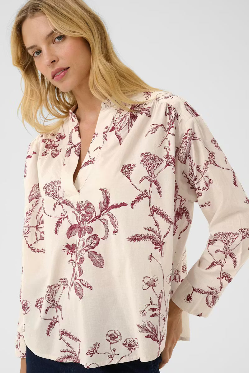 Natale Blouse. Floral print is made from a lightweight and airy fabric. Relaxed fit, a feminine V-neckline, and subtle puff sleeves for a modern touch.

Fit: Oversize
Composition :
100% Cotton (Organic)
Colour: 
Tawny Port Botanical Print

The Beach House Boutique, Rock Cornwall. 