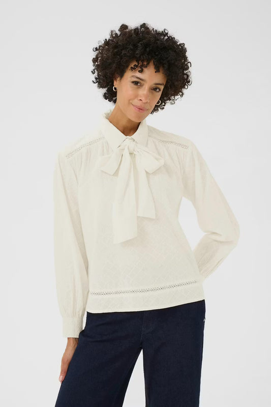 Sanella Blouse. Light cotton features delicate lace details, subtle texture, and a feminine bow at the neckline. Relaxed fit. 
Fit: Relaxed
Composition :
100% Cotton (Organic)
Colour: Eggnogg

The Beach House Boutique Rock, Cornwall. 