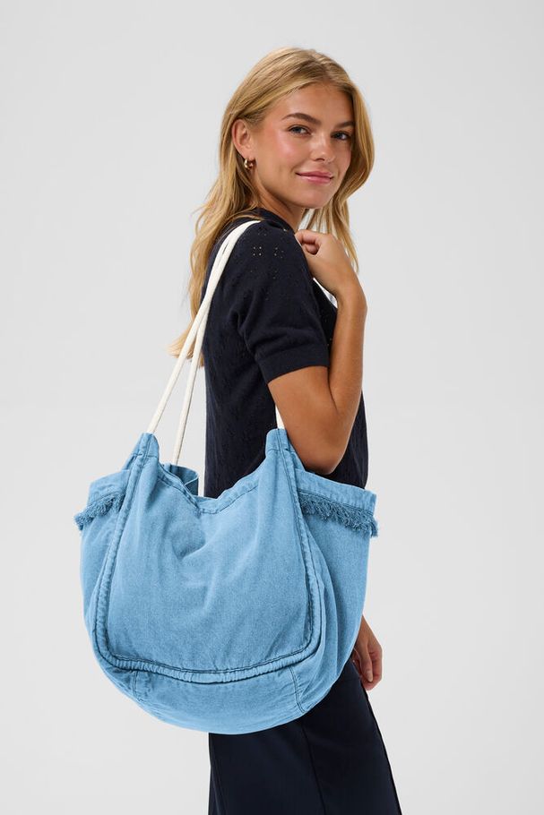 Othilde Bag. Mid blue denim wash. Long white shoulder straps. Frilly tassels for detailing. Large size bag. Main compartment space. 

Beach House Boutique Rock Cornwall